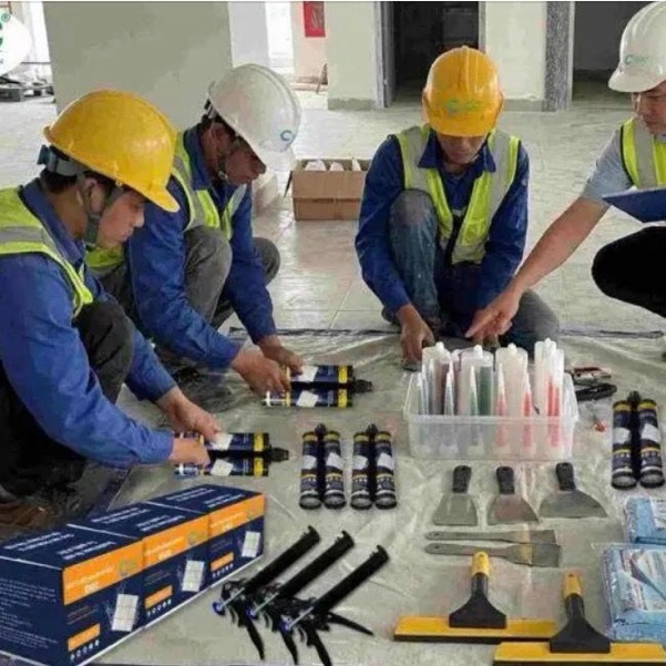 Đội thợ thi công keo VCC với keo, súng bắn và dụng cụ chít mạch